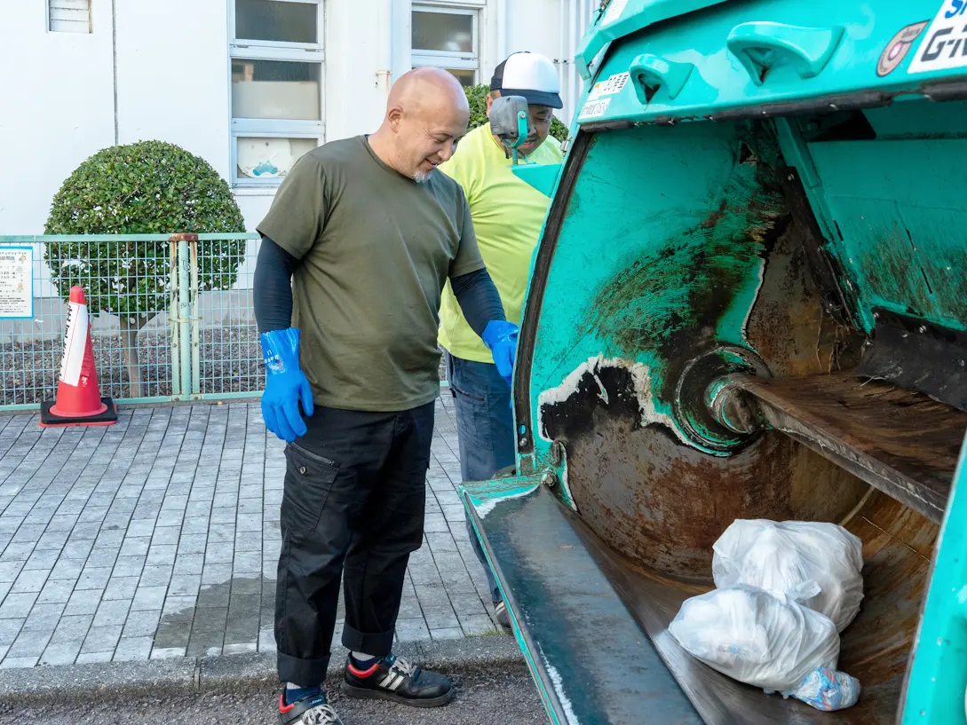 笑顔でごみ収集作業をする美濃環境保全社の社員